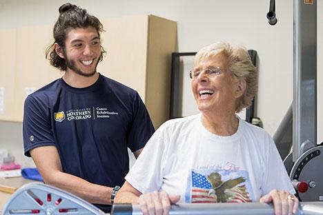 A UNC trainer and a client next to each other smiling.