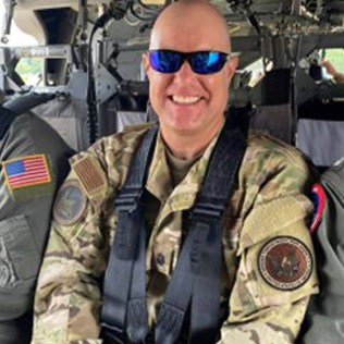 Lieutenant Colonel Scott McCoy strapped in and harnessed in a military vehicle.