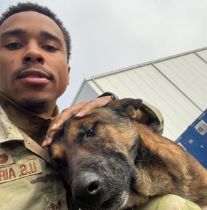Staff Sergeant Chris Santos taking a selfie with a German Shepard.