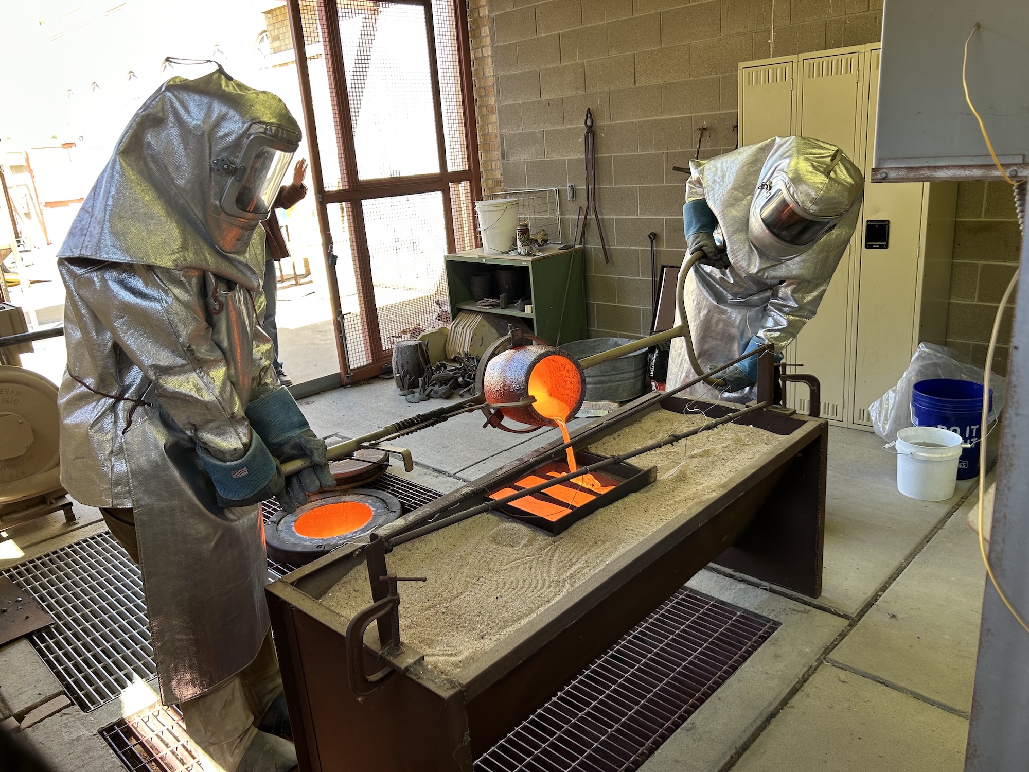 Students doing a bronze pour in the Maxine and Don Schwartz Sculpture Foundry.