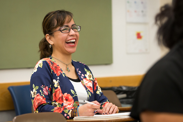 Professor Karla Del Carpio laughing while she teaches