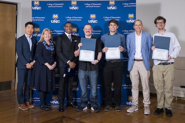 Three Economics students with four faculty and staff member at the Humanities and Social Science honored scholars' convocation 2025