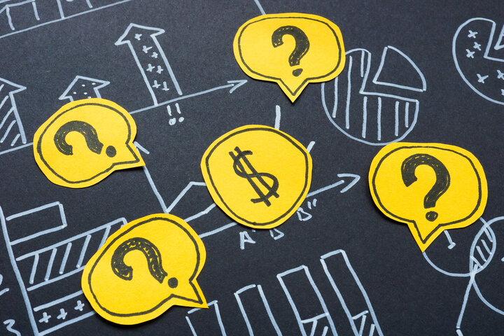 Question marks around a dollar. Financial investments and economic uncertainty.
