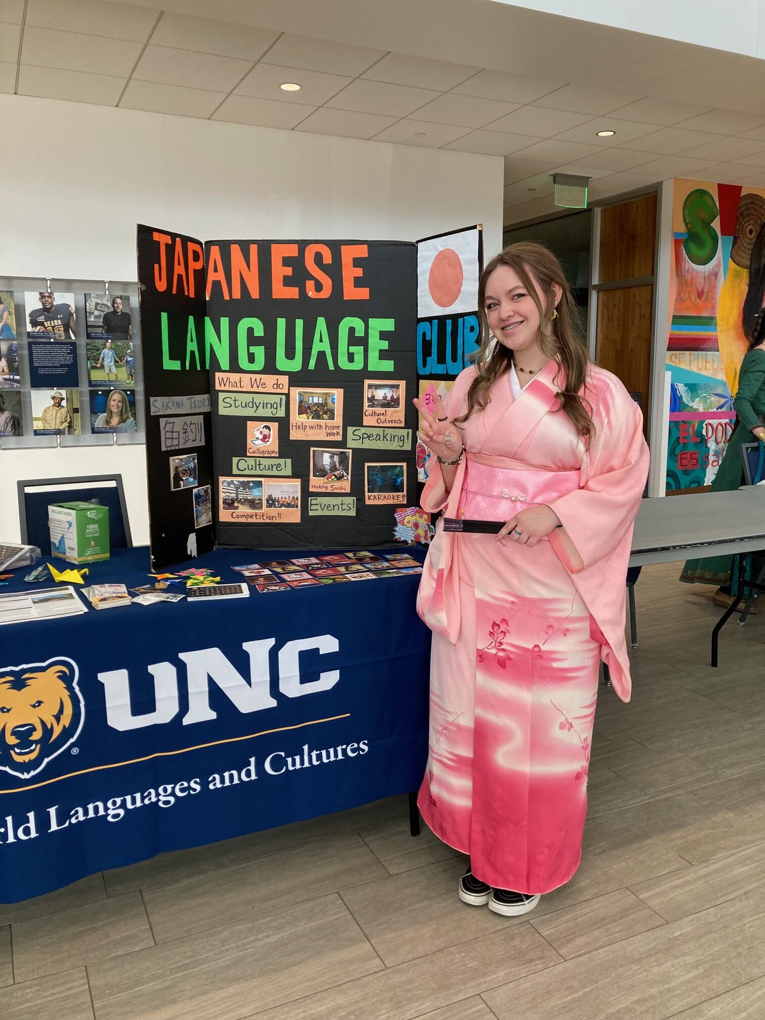 A student in cultural Japanese clothes outside a Japanese Language Club booth