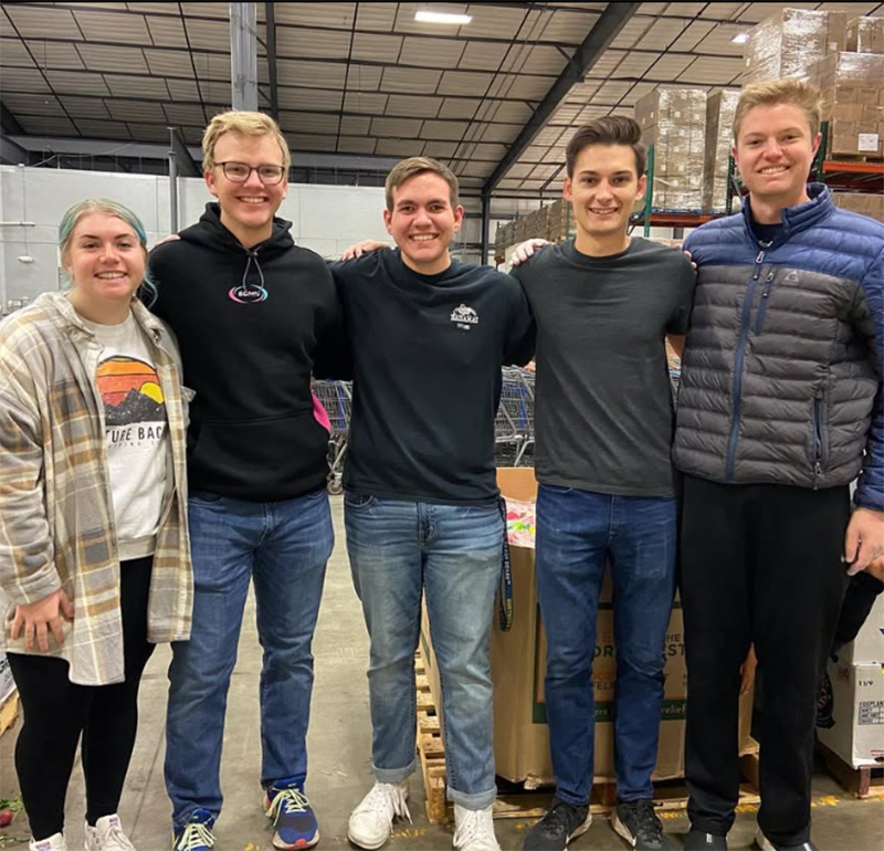 A group of students lined up, smiling and dressed in casual clothing, showcasing a cheerful and relaxed atmosphere