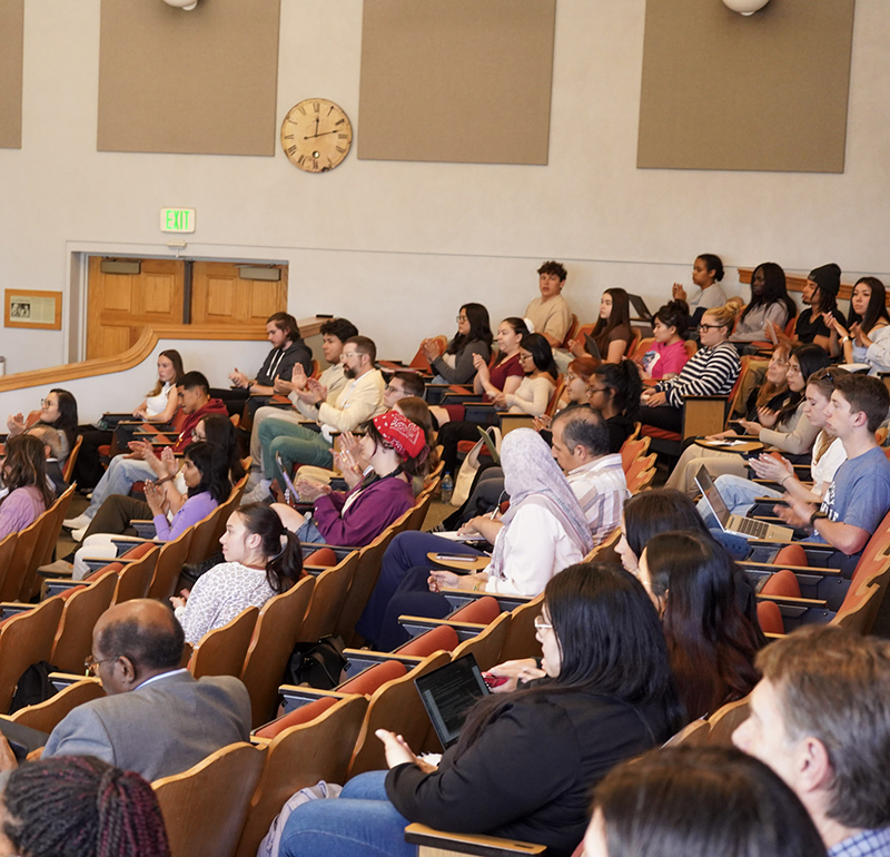 Audience members seated in an auditorium, attentively listening and engaging during Innovation Talks 2025, with some taking notes or using devices.