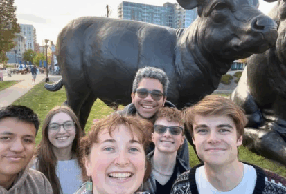 6 students in front of bull statue, outside the Art Museum