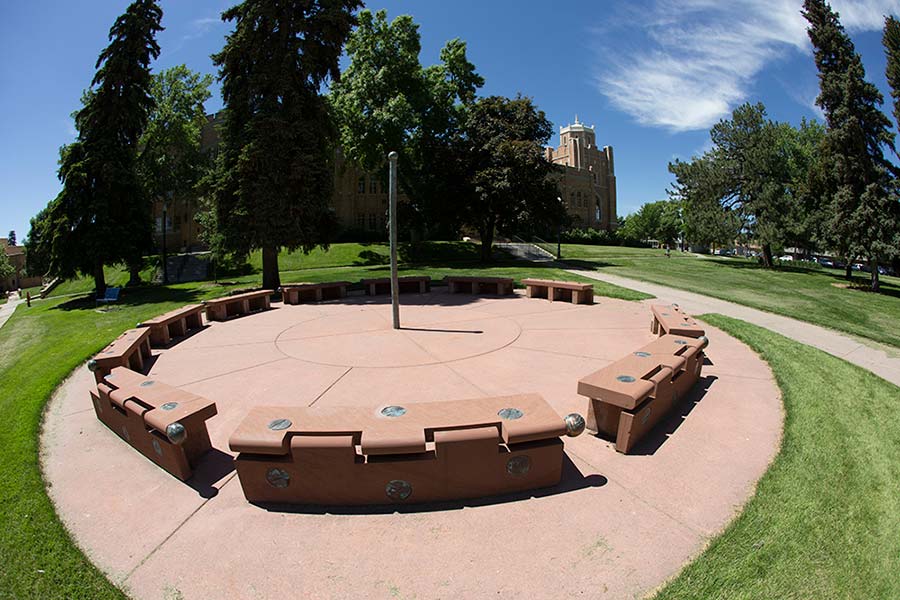 The stonehinge art display located north of Gunter Hall, the installation includes several stone benches displayed around a flag pole in a circle.