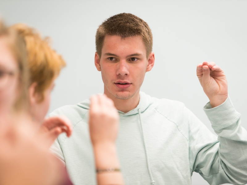 a young male student is shown signing in class