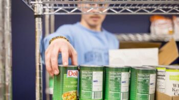 A student reaches for a can of food.