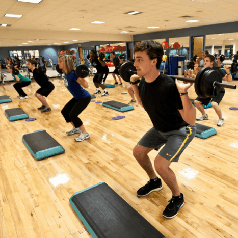 people exercising with weights together in a studio
