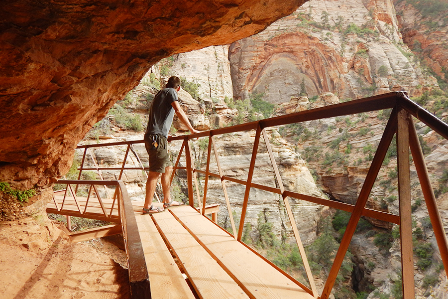 person looking over a ledge at zion national park