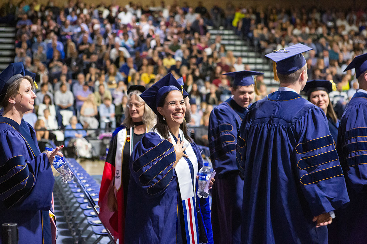 Doctoral student smiles at her commencement ceremony.