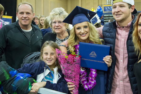 A UNC Graduate and her family pose with her degree.