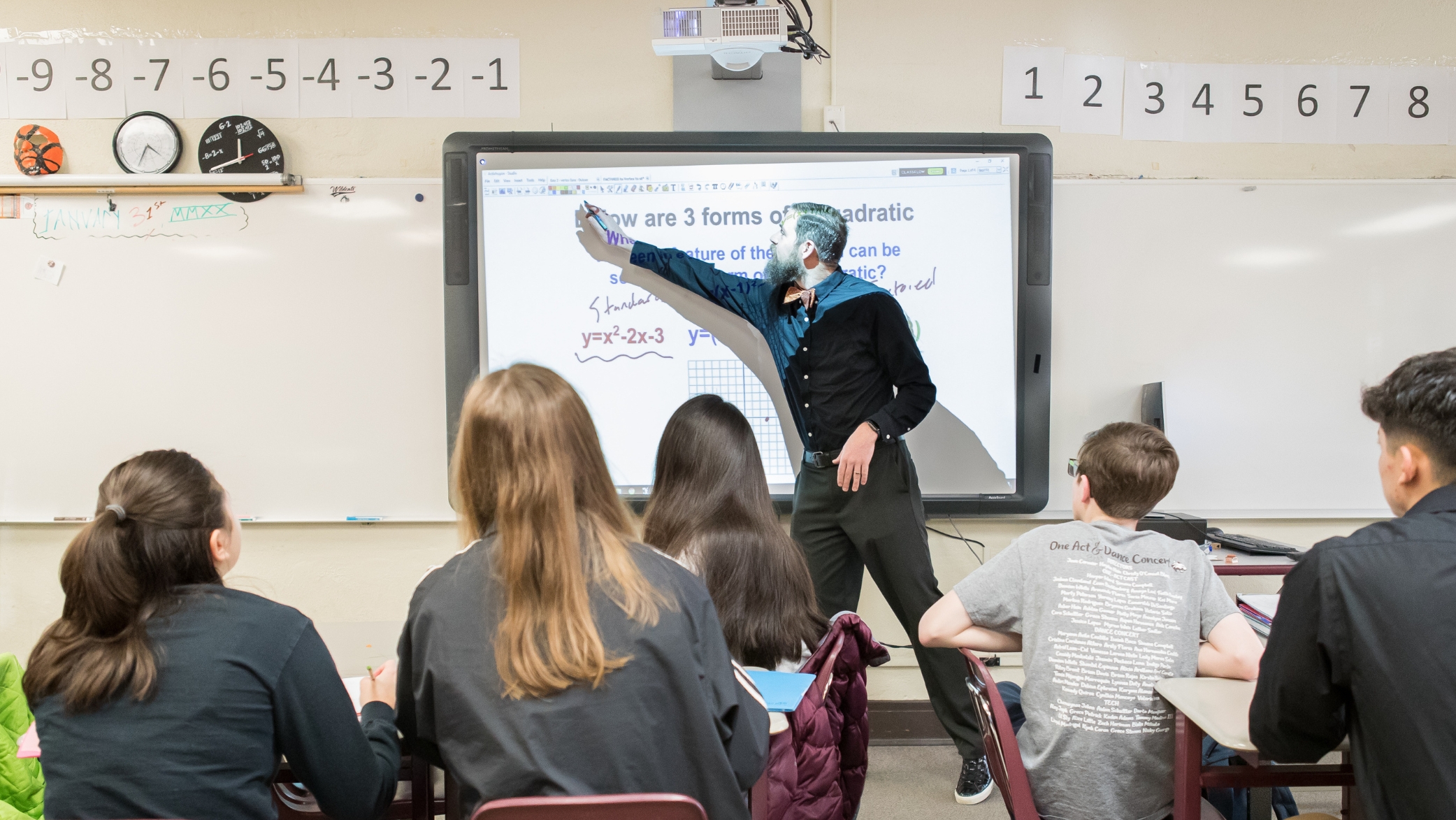 teacher teaching math in front of highschool students
