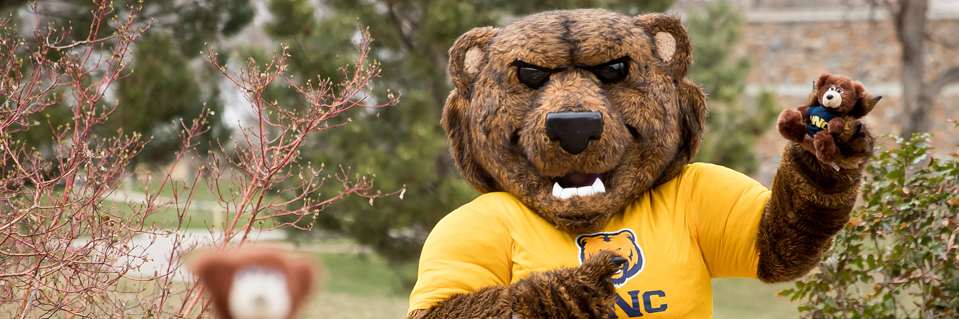 The Klaws mascot wears a UNC shirt and holds a small UNC bear.