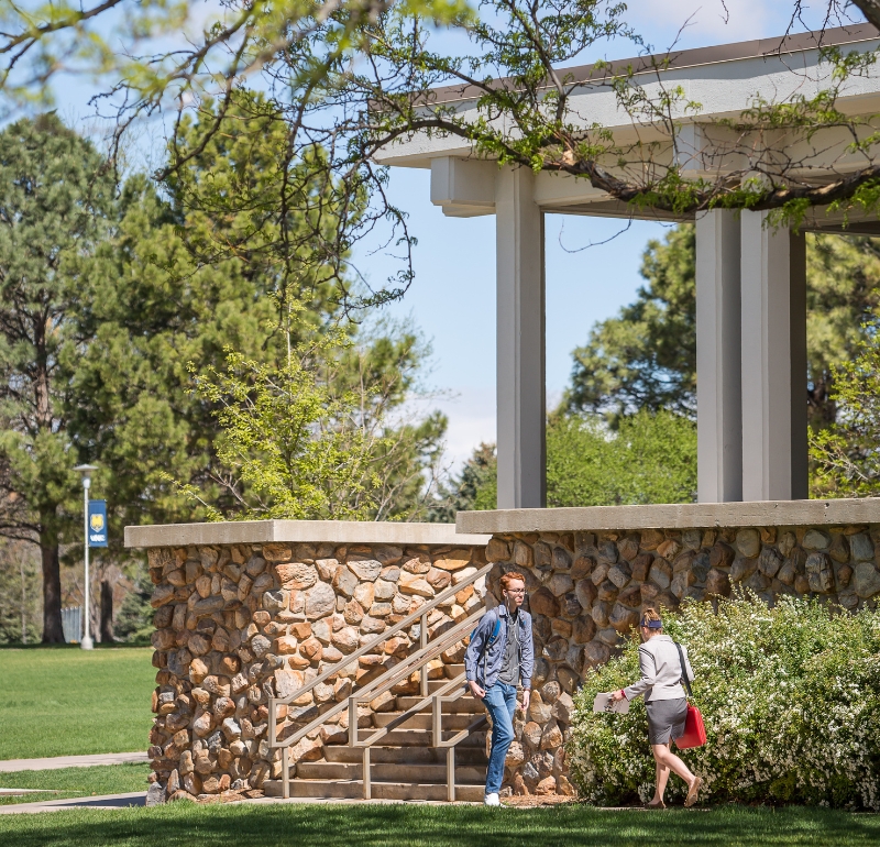 two students walking in front of McKee Hall building outside