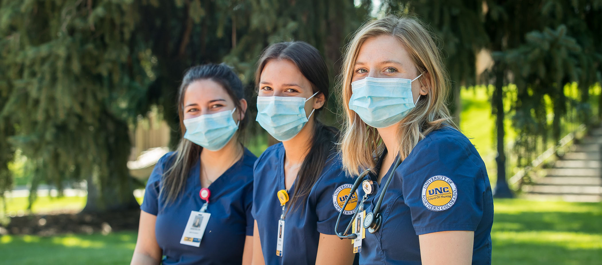 Several UNC nursing students pose in their UNC scrubs wearing protective masks.