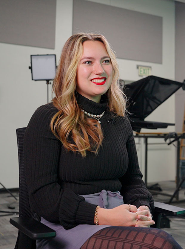 Alumni Sophia Tavanello sitting down in a newsroom.