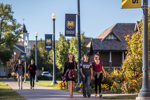 Students walk on the sidewalk on UNC's central campus.