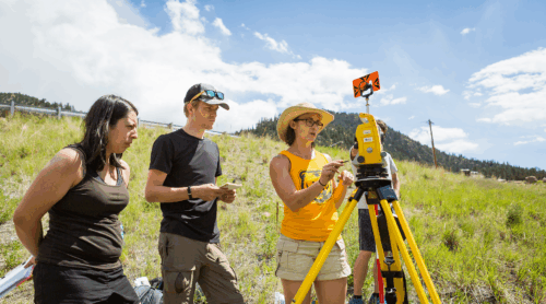 UNC students observe a machine in an open field.