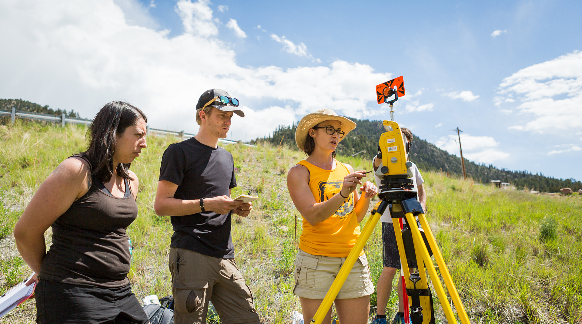 UNC students observe a machine in an open field.