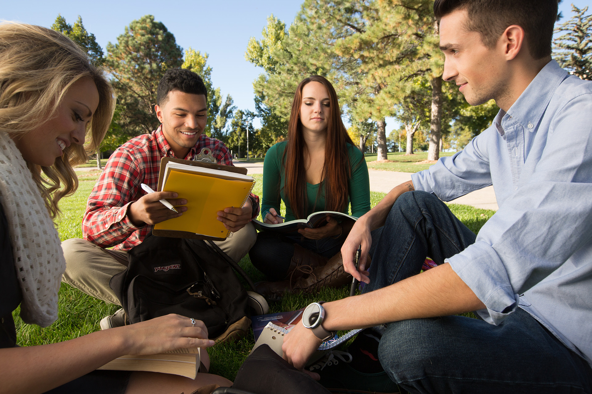 Students sit on UNC's front lawn writing in notebooks.