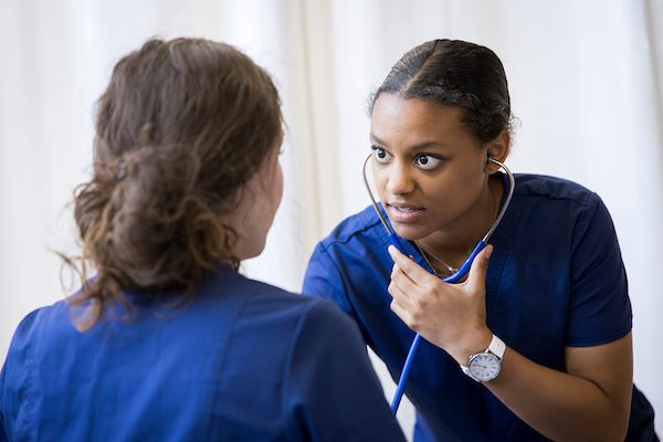 Nursing students participating in a lab simulation on clinical practices