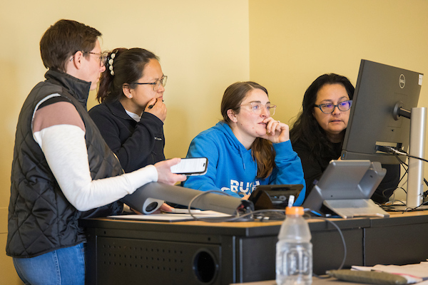 Professor reviewing lab simulations with students