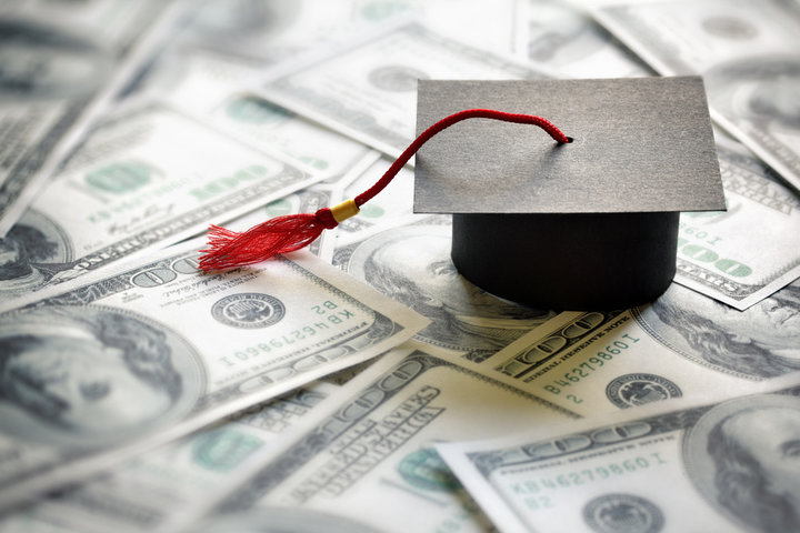 A graduation cap sitting on top of a money spread