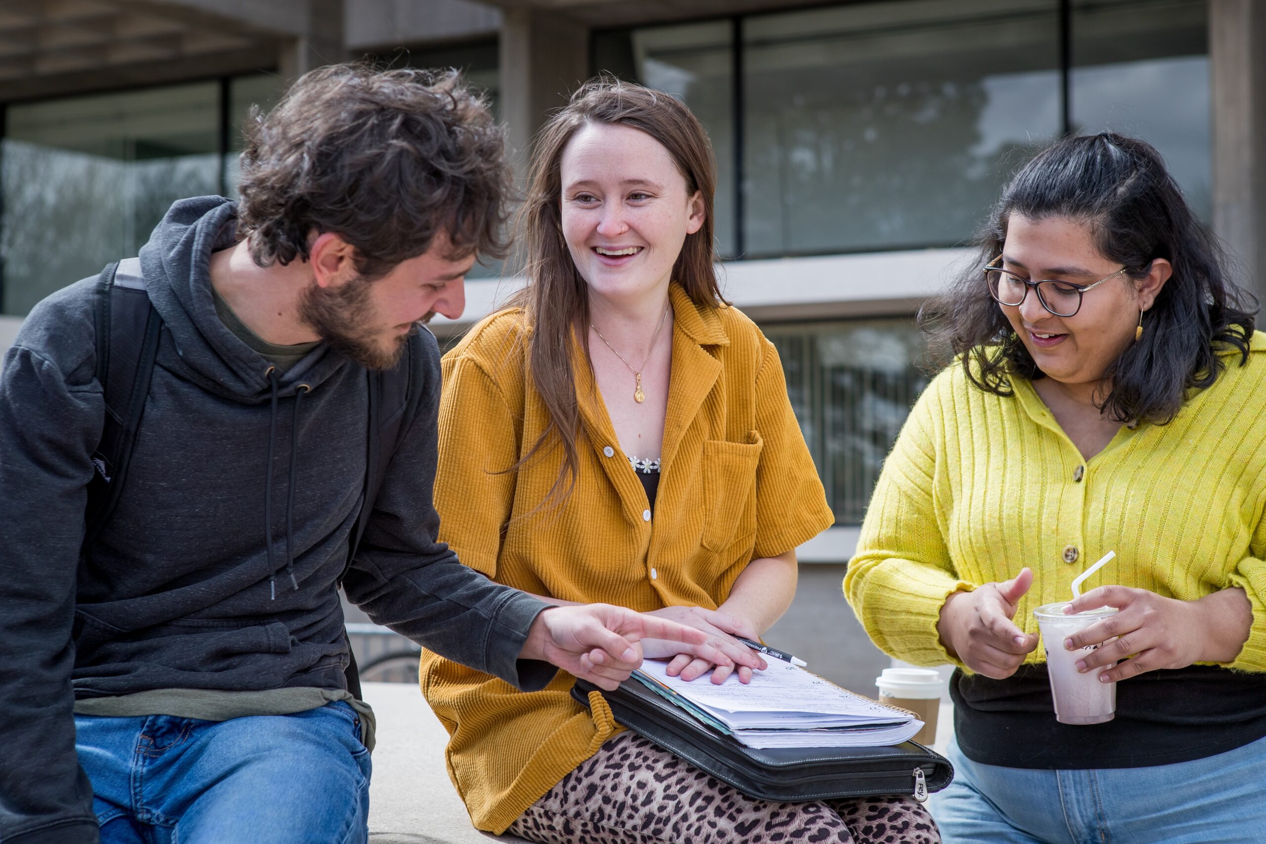 three students outside studying