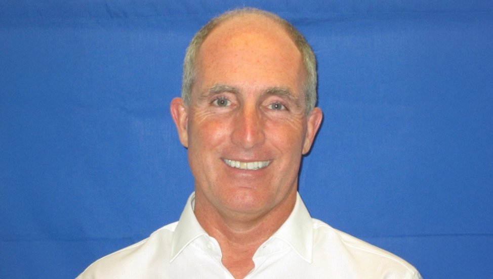 Protrait shot of Mark Wallace in front of blue background