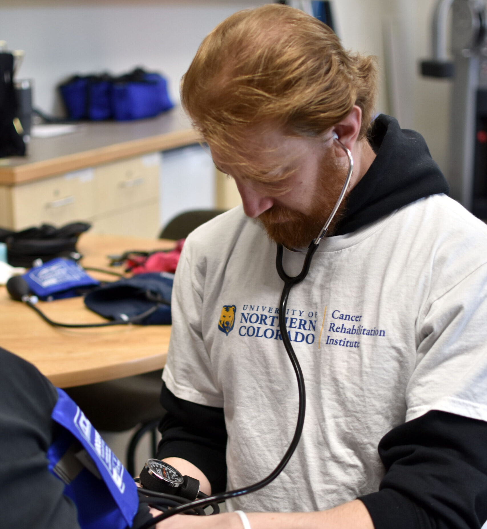 Nursing student taking person's blood pressure