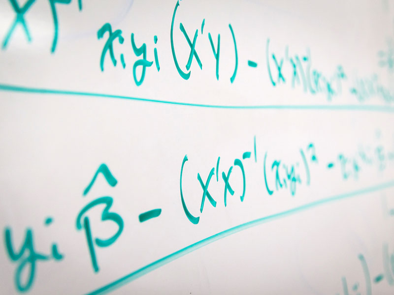 Mathematical equations written on a white board.