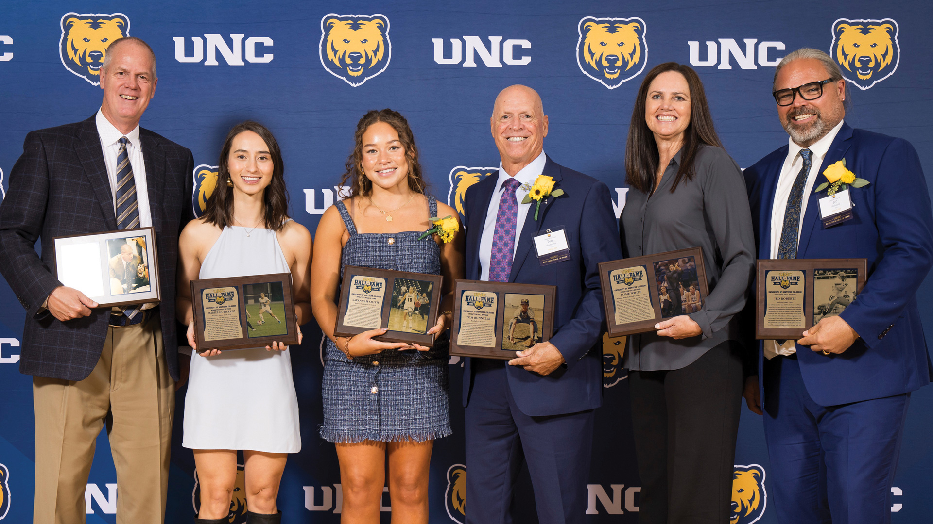 A group of six people standing next to eachother with plaques in their hand