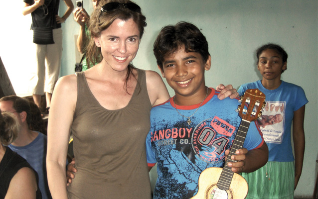 Karen Barton posing with a young boy with a ukelele