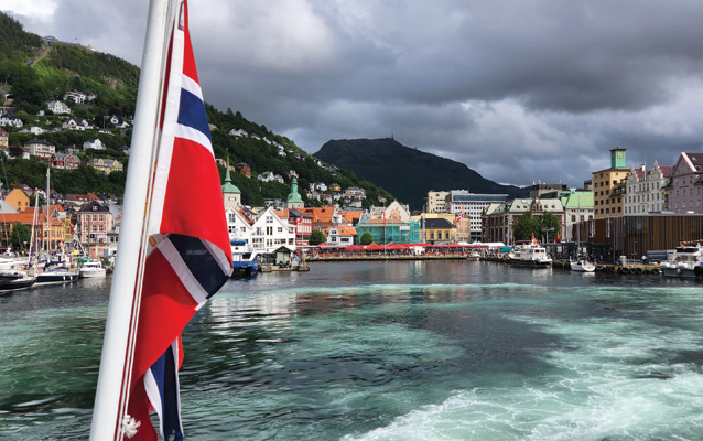 A colorful port town seen from the back of a boat.