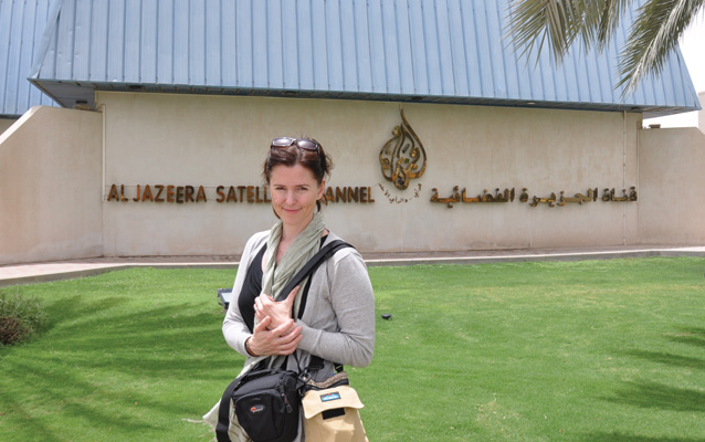 Karen Barton standing in front of an Al Jazeera building