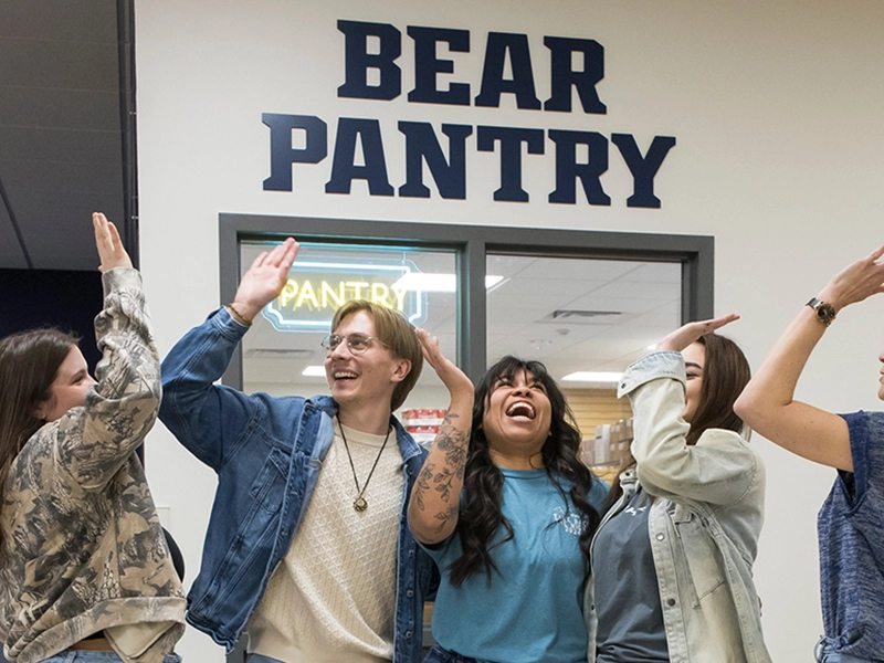ear Pantry staff high-five outside the campus community food pantry.