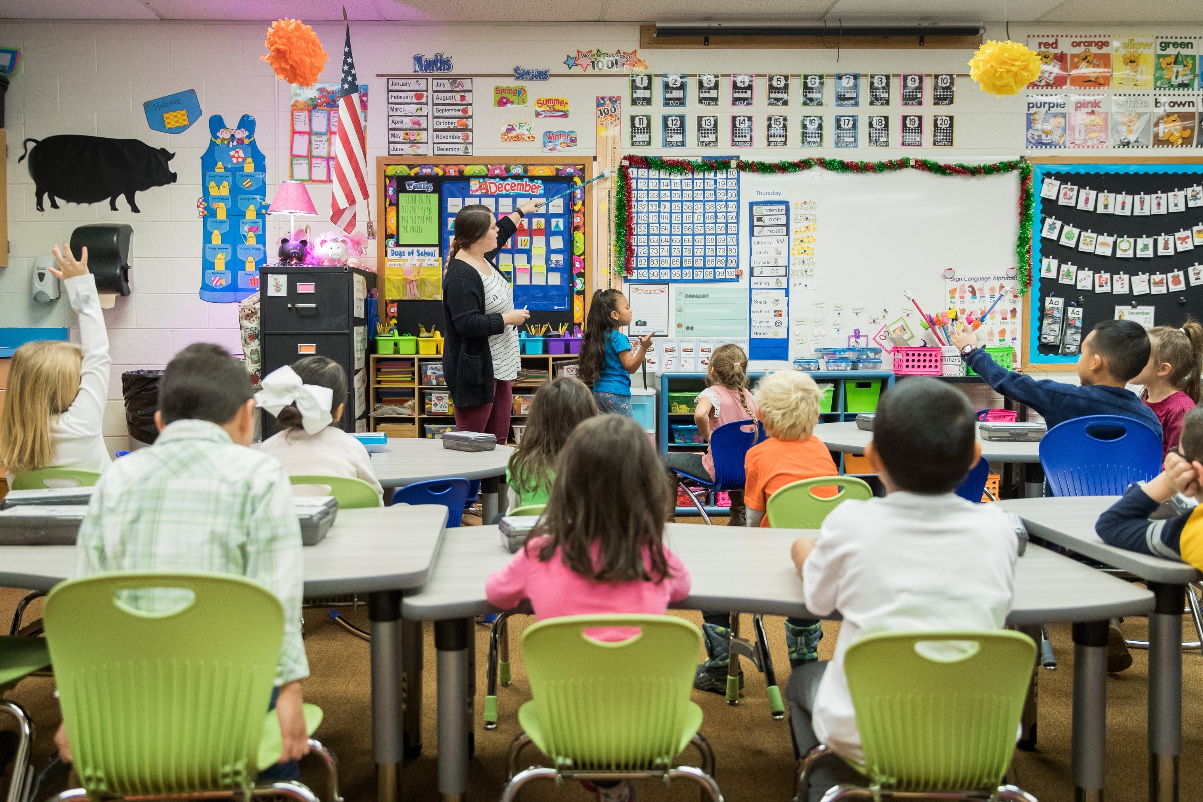 A teacher pointing at the board in her early childhood education classroom