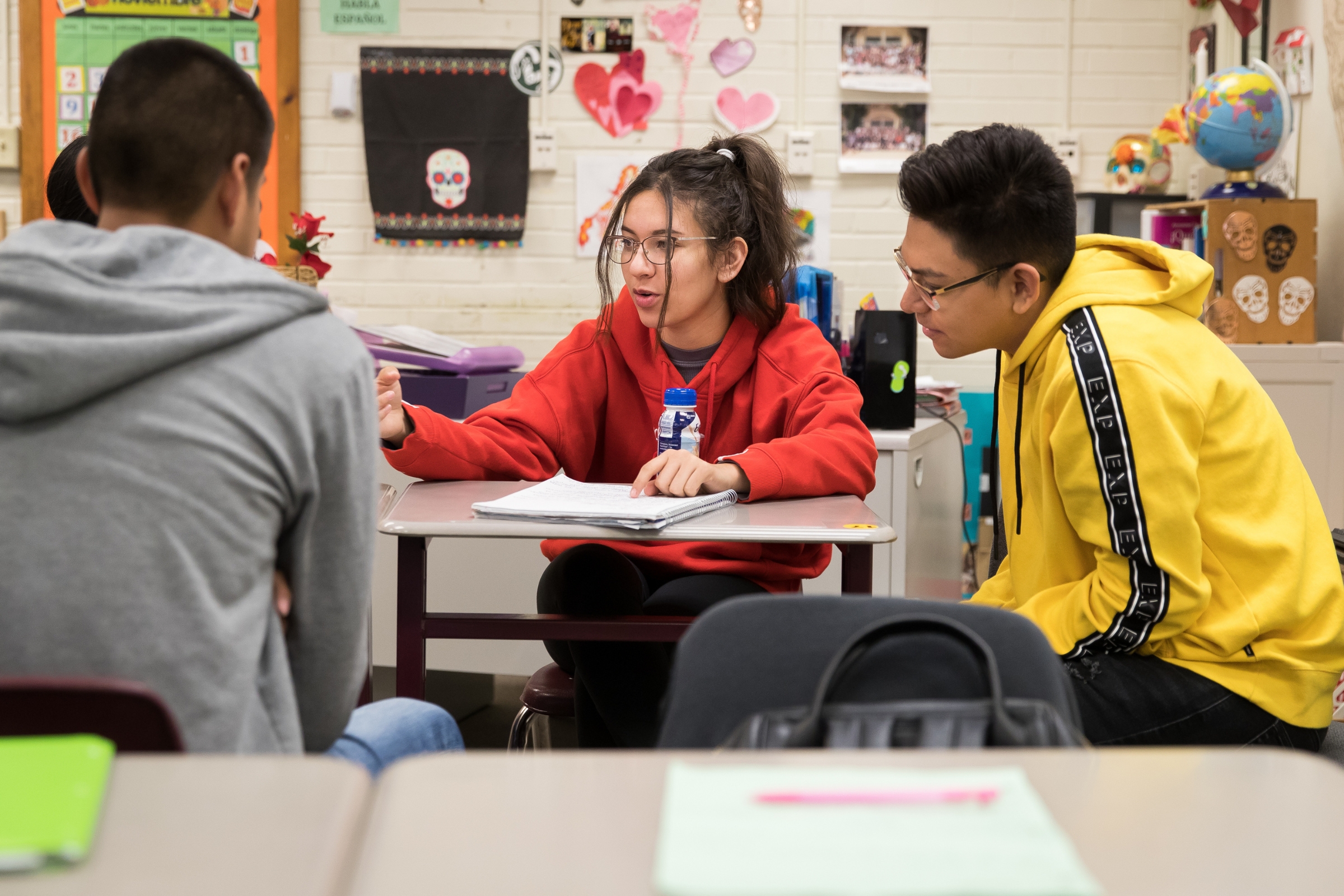 A group of four students are sitting talking to each other