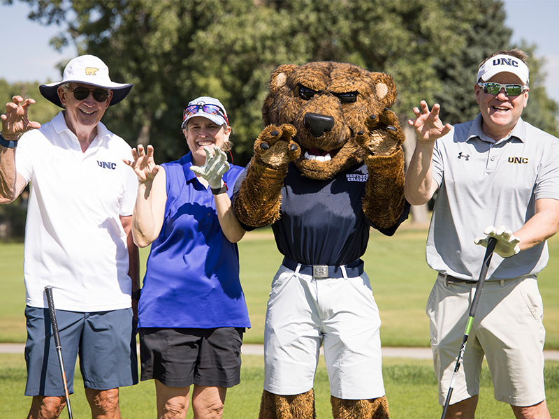 Golf participants pose with Klawz.