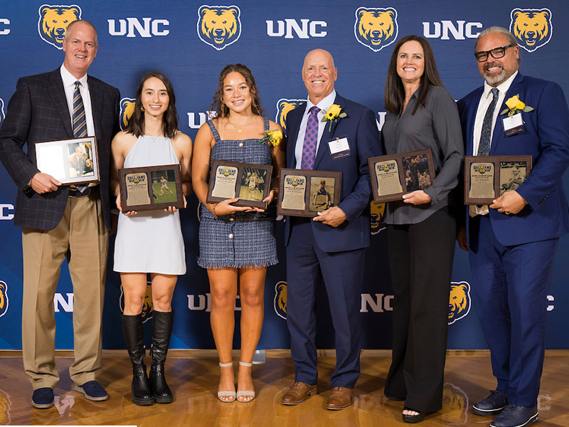 2024 Athletics Hall of Fame Inductees smile while holding their plaques.