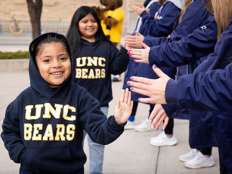 Young girls high-five the swim-team.