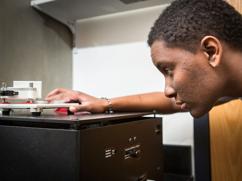 Graduate student calibrating a scientific instrument.