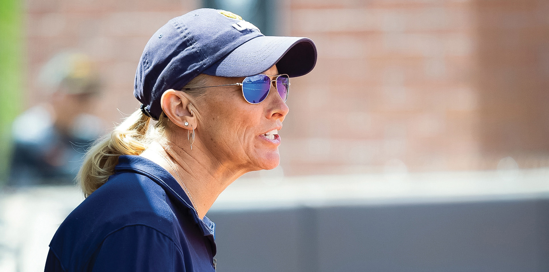 Coach P wearing a UNC cap and sunglasses watching a game