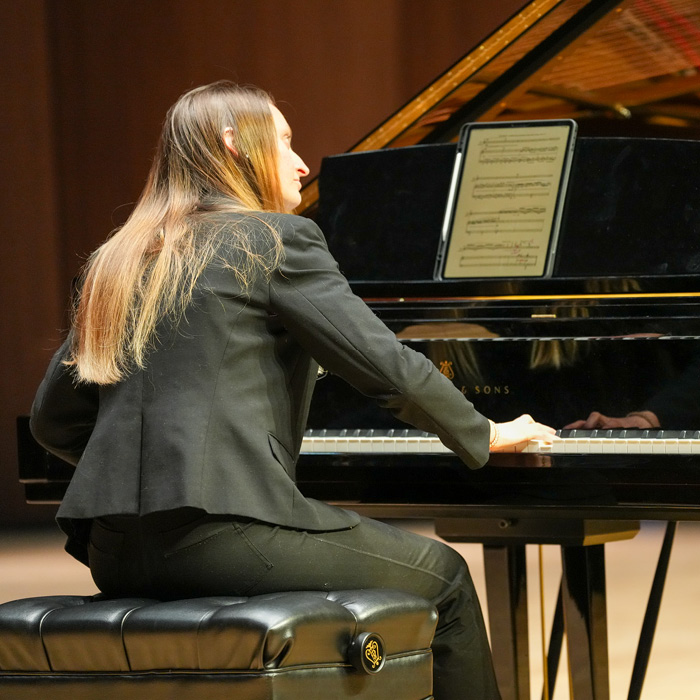 A collaborative pianist performing on stage during the PVA Spotlight concert.