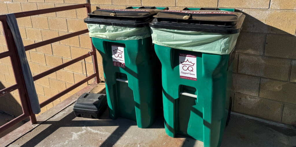 Two composting bins sitting outside a building.