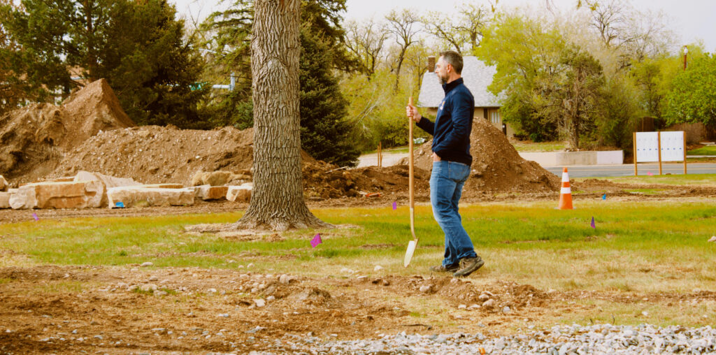 Chris Bowers holding a shovel outside.