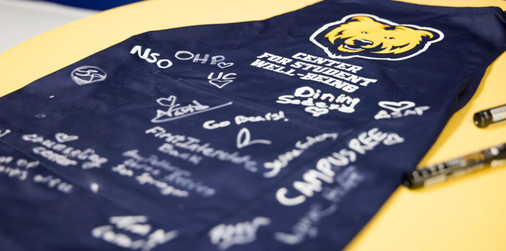 A navy apron that is signed by a bunch of people